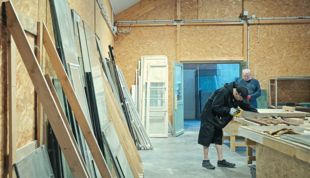 travailleurs recyclent des fenetres dans un atelier