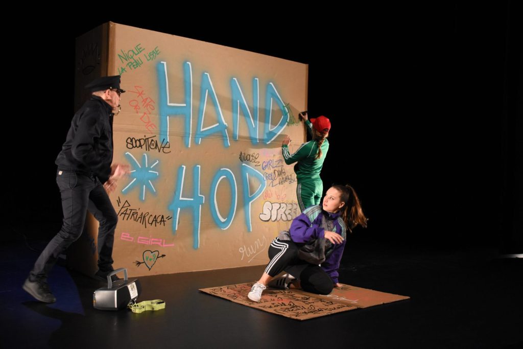 Trois comédiens sur une piste de danse improvisée en carton dans le spectacle Hand Hop de la compagnie Scopitone