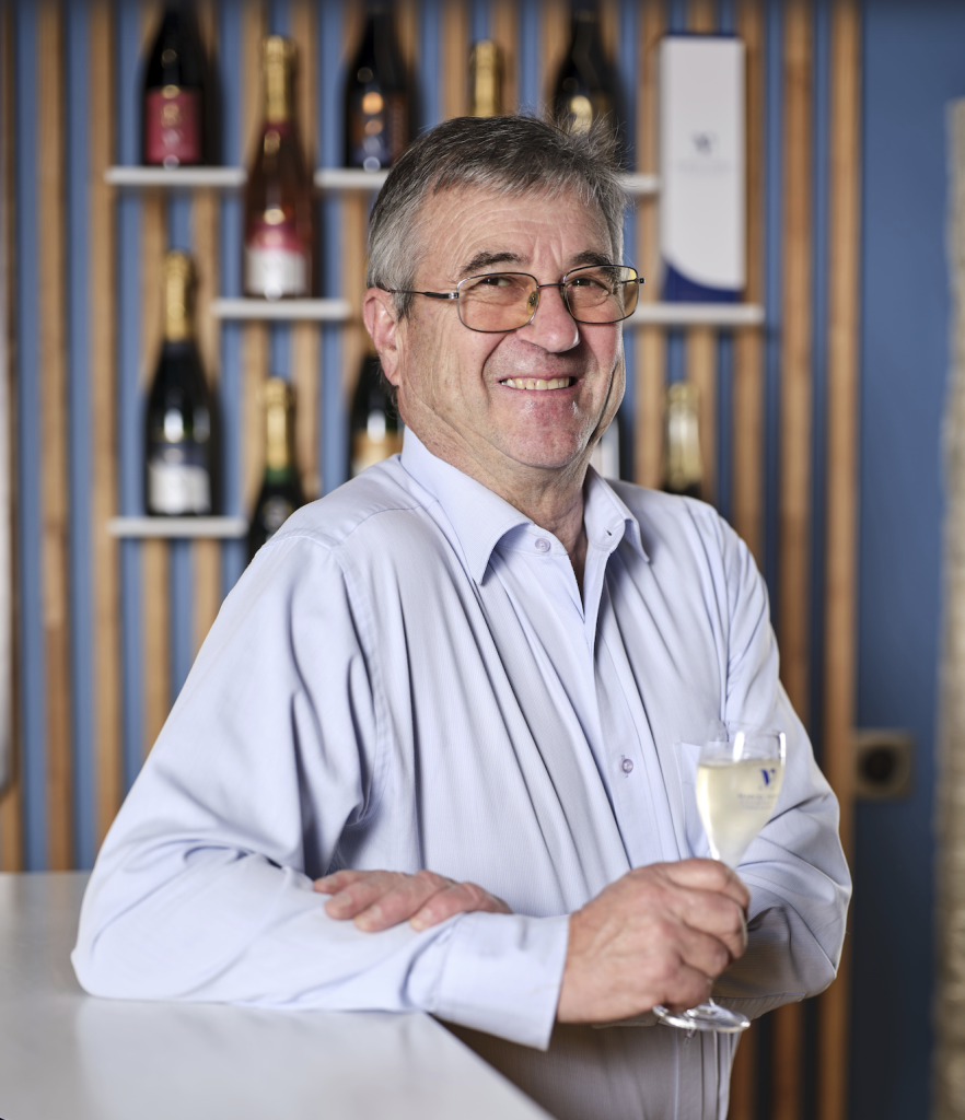 jean pierre vezien tient un verre de champagne