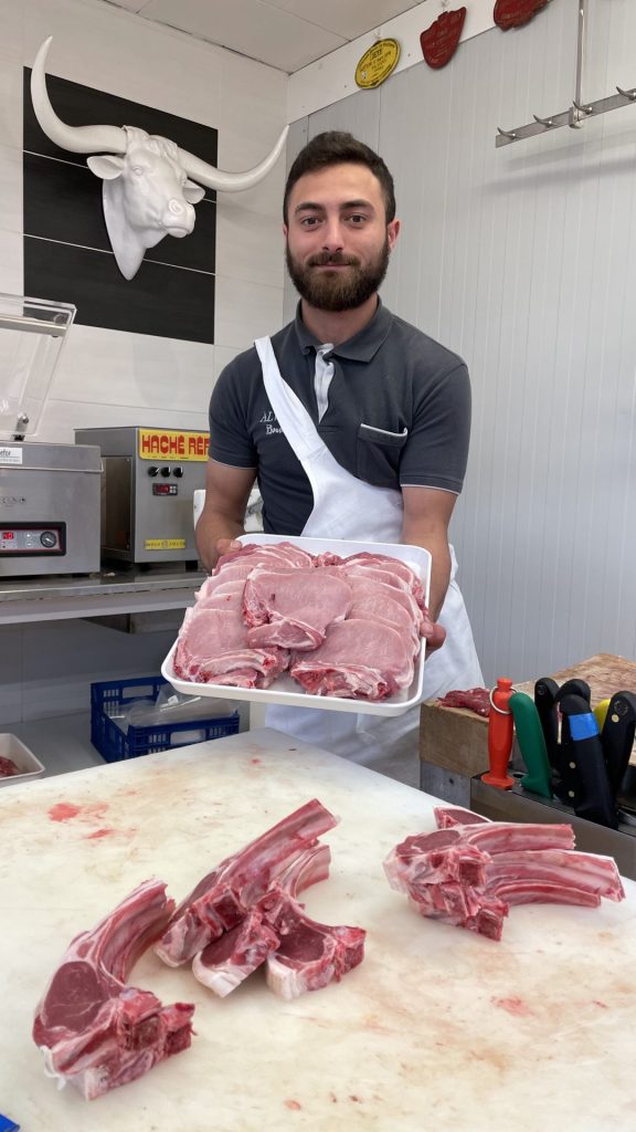 le jeune boucher Victor Ianooti présente un plat de viande découpée.