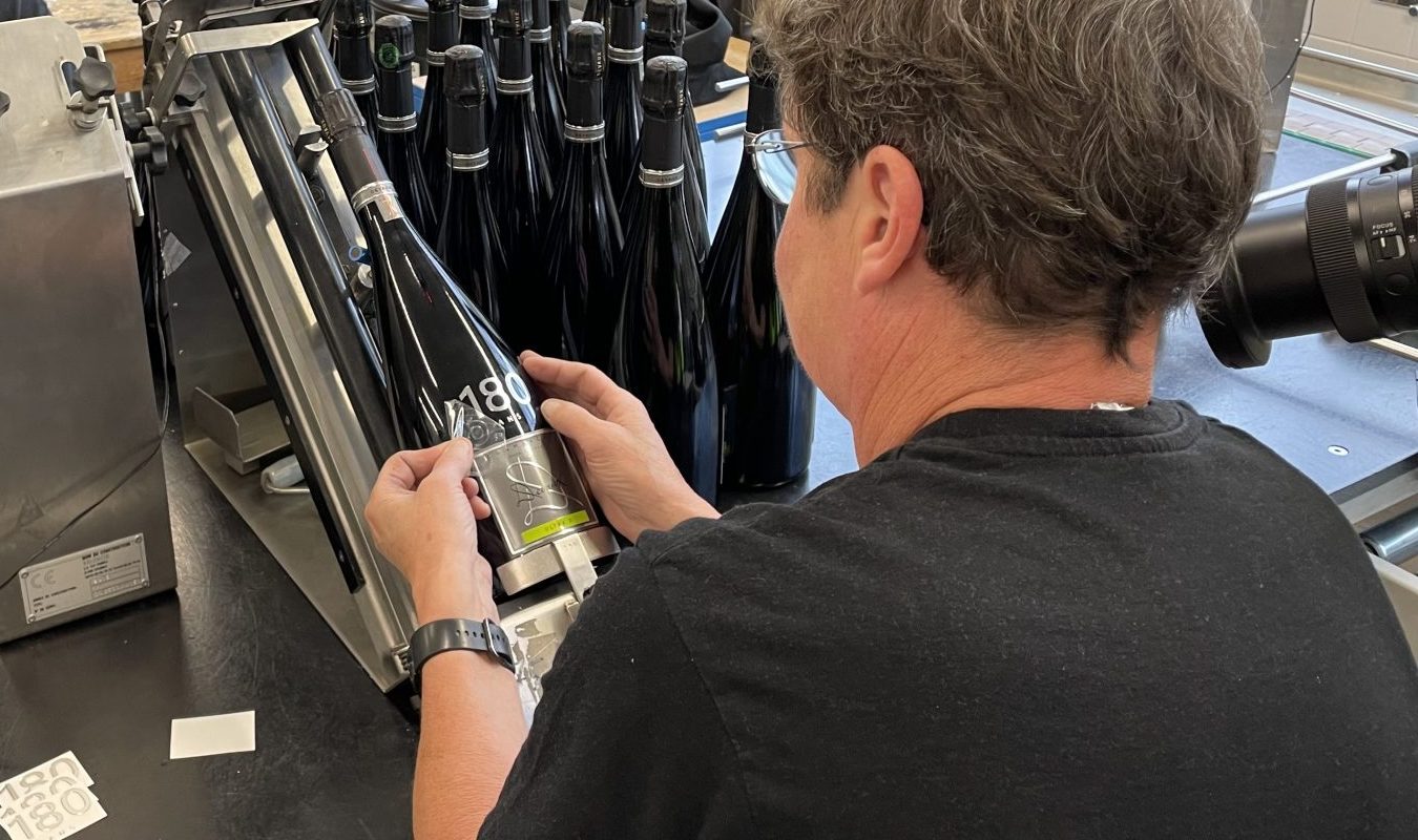 ouvriers étiquettent des magnums de champagne de la maison Devaux