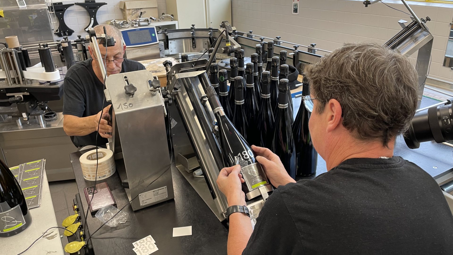 ouvriers étiquettent des magnums de champagne de la maison Devaux