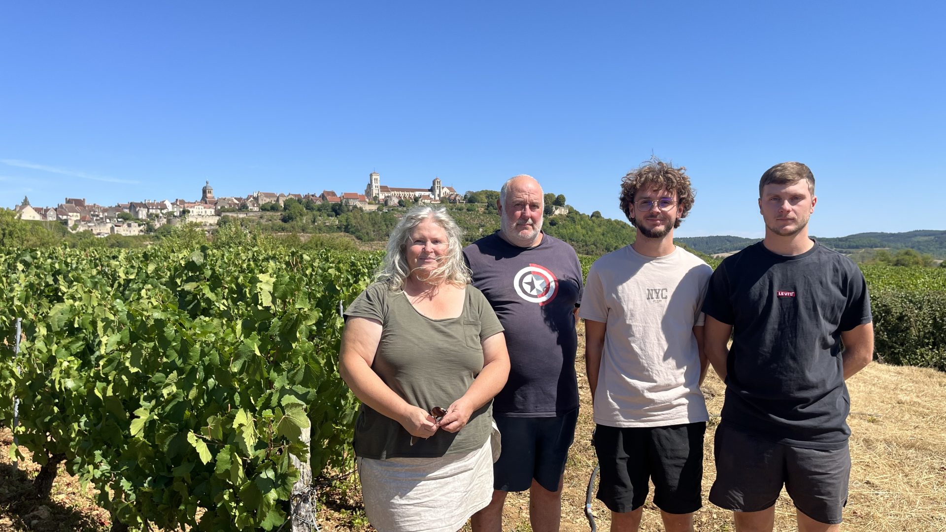 la famille garnier pose dans ses vignes avec la colline de Vézelay en fond